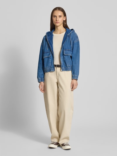 Modelka nosi Regular Fit Jeansjacke aus reiner Baumwolle Modell 'KENZIE' od Only, krój regular fit, denim, kieszenie z patkami, widok całej sylwetki z przodu.