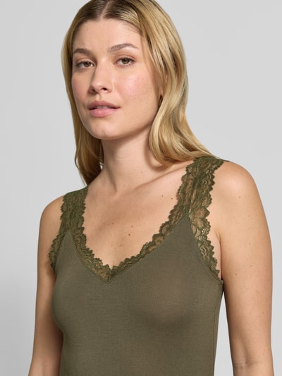 Kobiece model prezentuje oliwkowy top z koronkowym wykończeniem, Slim Fit Tanktop aus Viskose-Mix Modell 'ROSA' od VERO MODA, zbliżenie na górną część ciała.