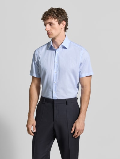 Männermodel trägt Regular Fit Business-Hemd aus Baumwolle mit Kentkragen von Christian Berg Men, weiß-blau, feine Streifen, Ganzkörperansicht von vorne.