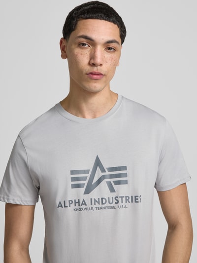 Mężczyznamodel prezentuje męski t-shirt z bawełny, prosty krój, okrągły dekolt, detal z logo, model 'BASIC' od Alpha Industries, długość tyłu w rozmiarze M: 69 cm, jasnoszary, gładka faktura, nahaufnahme oberkörper.