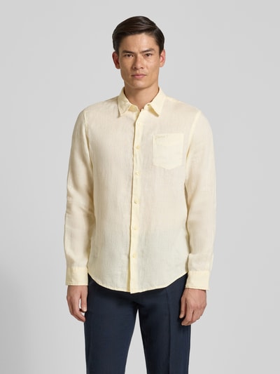Männermodel trägt Regular Fit Leinenhemd mit Kentkragen und Brusttasche von Guess in Creme, strukturierte Oberfläche, Ganzkörperansicht von vorne.