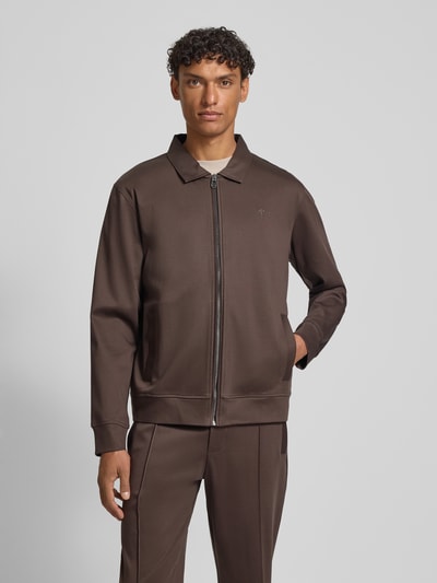 Männermodel trägt Sweatjacke mit Logo-Stitching Modell 'Ricardio' von JOOP! Collection, dunkelbraune Baumwolle, gerader Schnitt, Ganzkörperansicht von vorne.