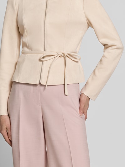 Frauenmodel trägt Blazer mit Reißverschluss und Bindegürtel von Zero in hellem Material-Mix mit Stretch-Anteil, taillierter Schnitt, Rundhalsausschnitt, Nahaufnahme Oberkörper. Rückenlänge bei Größe 36: 50 cm, Brustweite 44 cm, Ärmellänge 61 cm.