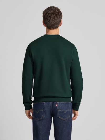 Männermodel trägt Regular Fit Sweatshirt aus reiner Baumwolle von Lacoste, Optik: Unifarben, Langarm, Ganzkörperansicht Rückansicht.