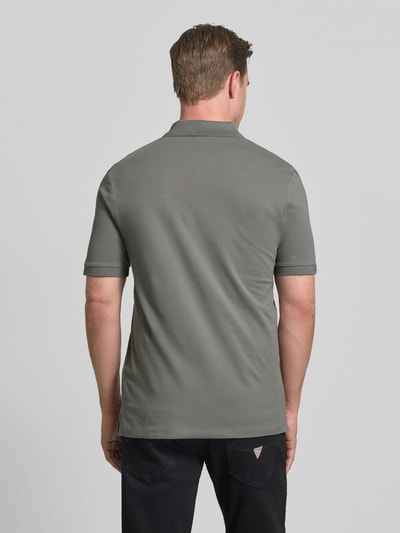 Männermodel trägt Regular Fit Poloshirt aus reiner Baumwolle Modell 'DONOS222' von HUGO in Grau, glatte Webware, Ganzkörperansicht Rückansicht.