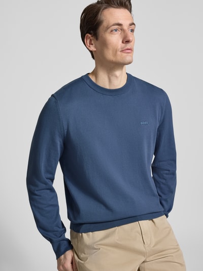Männermodel trägt Regular Fit Strickpullover aus reiner Baumwolle Modell 'UPCAS' von BOSS, Optik: Unifarben, Nahaufnahme Oberkörper.