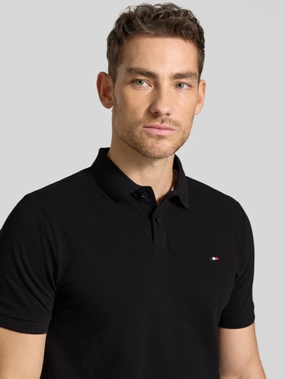 Męski model nosi Regular Fit Poloshirt mit Logo-Stitching von HECHTER PARIS, bawełna, fakturowany wzór, czarny, kołnierzyk polo, z krótkim rękawem, długość tyłu w rozmiarze M: 66 cm, z przodu, zbliżenie górnej części ciała.