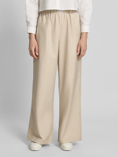 Frauenmodel trägt Wide Leg Hose aus Viskose-Mix Modell 'TOSCA' von VILLA SOPHIE in Optik: Unifarben mit seitlichen Eingrifftaschen, Bundabschluss: elastisch, Passform: Wide-Leg, Material: Viskose-Mix, beige, glatte Textur, Ganzkörperansicht von vorne.