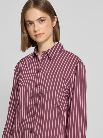 Frauenmodel trägt Oversized Hemdbluse aus Viskose-Mix Modell 'MELDOLA' von Only, gestreiftes Allover-Muster in Lila, Nahaufnahme Oberkörper.