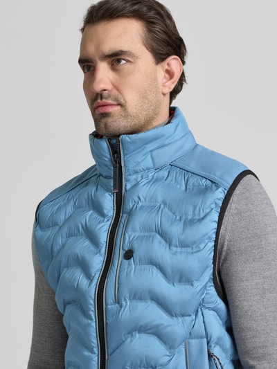 Männermodel trägt Regular Fit Steppweste mit Kapuze im Kragen von Tom Tailor, unifarben, reflektierende Details, Nahaufnahme Oberkörper.