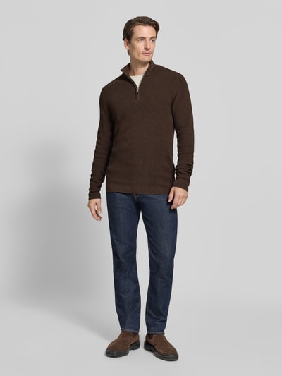 Männermodel trägt Slim Fit Troyer aus Baumwoll-Mix von Matinique, dunkelbraun, Stehkragen, gerippte Bündchen, Jeans, Ganzkörperansicht von vorne.