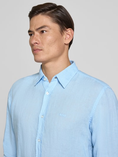 Männermodel trägt Regular Fit Freizeithemd aus reinem Leinen Modell 'RELEGANT' von BOSS Orange in Hellblau, Nahaufnahme Oberkörper.