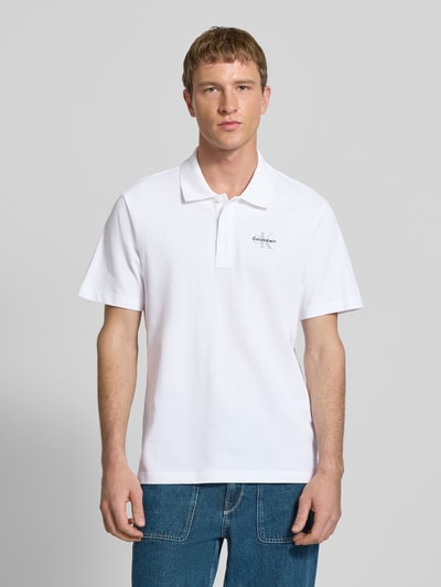 Männermodel trägt Easy Fit Poloshirt mit Polokragen von Calvin Klein Jeans aus reiner Baumwolle, mit Label-Stitching, Ganzkörperansicht von vorne.