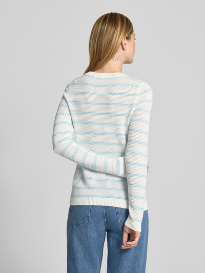 Vrouwenmodel draagt gebreide pullover met ronde hals Model 'DALO' van Vila, puur katoen, slim fit, ruglengte maat S 56 cm, mouwlengte S 65 cm, lichtblauw-wit gestreept, grofgebreide textuur, rechte zoom, jeans, geheel achteraanzicht.
