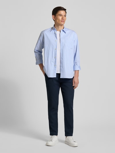 Männermodel trägt Tapered Fit Chino aus Baumwoll-Mix Modell 'CHINO PLEATED' von BOSS Orange, Optik: Unifarben, Ganzkörperansicht von vorne.