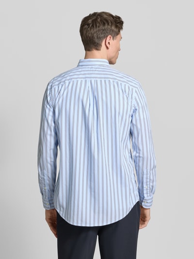 Männermodel trägt Regular Fit Freizeithemd aus reiner Baumwolle von Tommy Hilfiger, gestreift, langarm, blau-weiß, Ganzkörperansicht Rückansicht.