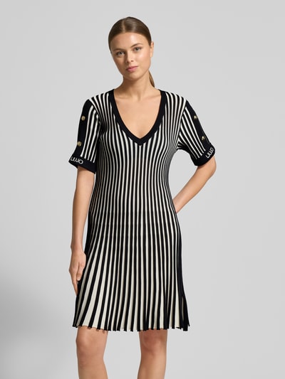 Frauenmodel trägt Minikleid mit gerippten Abschlüssen von LIU JO SPORT, schwarz-weiß gestreift, V-Ausschnitt, Nahaufnahme Oberkörper.