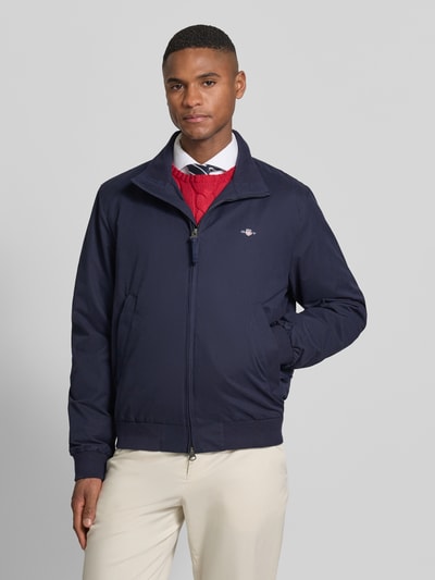 Mannenmodel draagt Jacke mit Stehkragen und Zweiwege-Reißverschluss van Gant in donkerblauw katoenmix met opstaande kraag, steekzakken, labelstitching, regular fit, vooraanzicht bovenlichaam.