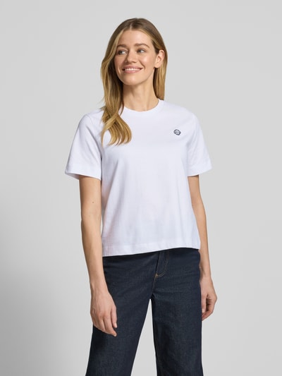 Modelka kobieca nosi Boxy Fit T-Shirt aus reiner Baumwolle Modell 'ELLA' od Selected Femme, biała gładka bawełna, okrągły dekolt, krój boxy fit, widok całej sylwetki z przodu