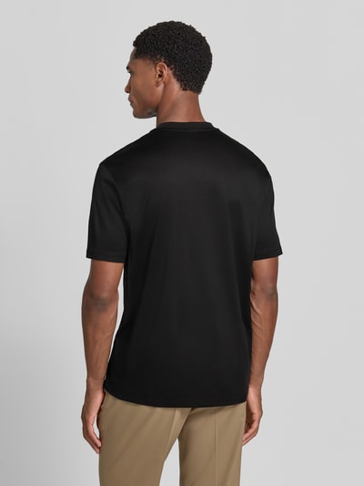 Männermodel trägt T-Shirt aus Lyocell-Mix mit Label-Stitching von Emporio Armani in Schwarz, schlichte Textur, Ganzkörperansicht Rückansicht. Taillierte Passform, Rundhalsausschnitt, Rückenlänge 69 cm bei Größe M, Baumwoll-Anteil.