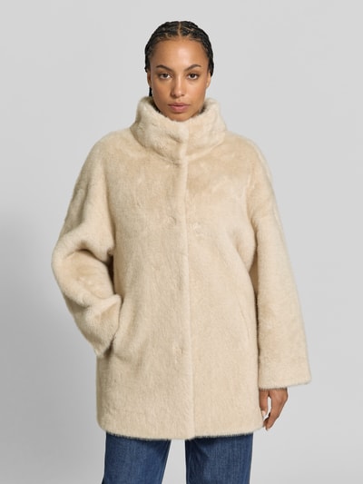 Vrouwenmodel draagt Kunstfelljacke met Stehkragen van Juvia in lichtbeige imitatiebont, a-lijn, afdekstrip, jeans, Ganzkörperansicht von vorne. Ruglengte maat S: 80 cm, borstwijdte maat S: 50 cm, mouwlengte maat S: 62 cm.