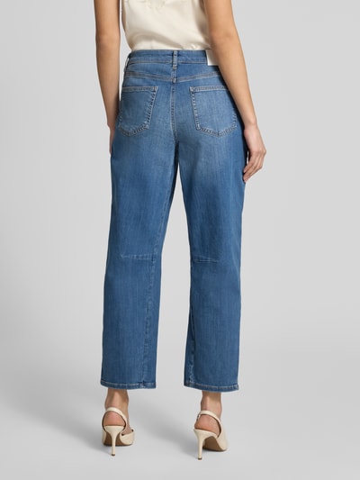 Modelka kobieca nosi Straight Fit Jeans im 5-Pocket-Design Modell 'Melly' od OPUS PANTS, mieszanka bawełny z dodatkiem streczu, krój relaxed fit, zapięcie na guzik i zamek błyskawiczny, szerokość w rozmiarze 36/28: 39 cm, długość wewnętrzna nogawki: 69 cm, wyrazisty niebieski dżins, prosty fason, gładka tekstura, widoczne szwy, widoczne tylne kieszenie, widoczna cała sylwetka od tyłu.