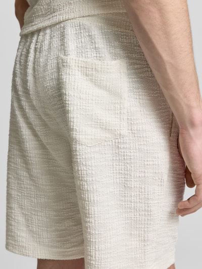 Männermodel trägt Shorts mit elastischem Bund von MCNEAL aus Material-Mix mit Baumwoll-Anteil, Strukturmuster, Nahaufnahme Oberschenkel.
