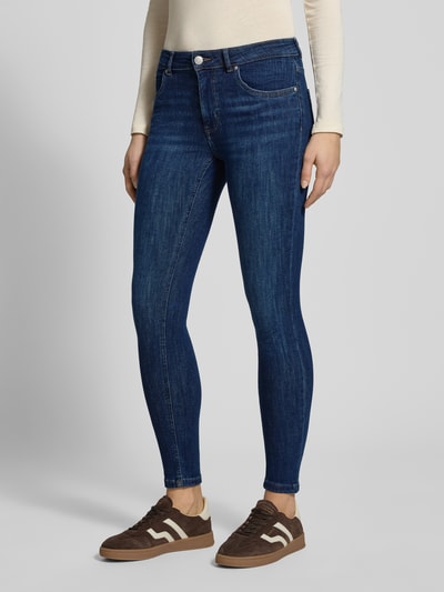 Frauenmodel trägt Slim Fit Jeans im 5-Pocket-Design von Review aus elastischem Baumwoll-Mix in Dunkelblau, Ganzkörperansicht von vorne.