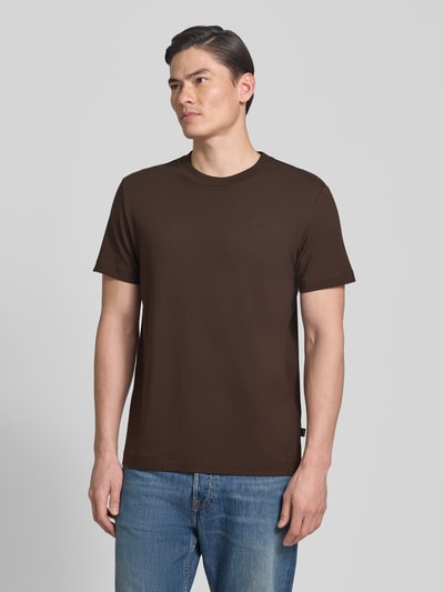Męski model nosi T-Shirt mit Rundhalsausschnitt Modell 'Carlonito' od JOOP! Collection, bawełniany miks ze stretchem, krój straight fit, detal z logo, brązowy, przód, zdjęcie całej sylwetki. Długość tyłu w rozmiarze M: 71 cm.