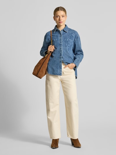 Modelka nosi Loose Fit Jeansbluse aus reiner Baumwolle von s.Oliver RED LABEL, denim, haftowany motyw, luźny krój, bawełniany twill, widok całej sylwetki z przodu.