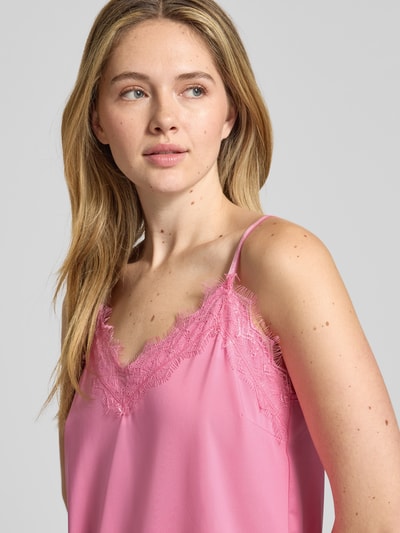 Kobiece modelka nosi Top mit Spitzenbesatz Modell 'BICCO' von FREE/QUENT, różowy kolor, elastyczny materiał, dopasowany krój, koronkowe wykończenia, regulowane ramiączka, długość tyłu w rozmiarze S: 38 cm, zbliżenie na górną część ciała z przodu.