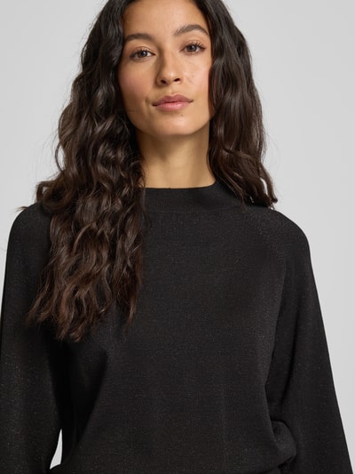 Frauenmodel trägt Strickpullover aus Viskose-Mix Modell 'MOBBE' von B.Young in Schwarz, Regular-Fit, Stehkragen, Nahaufnahme Oberkörper.