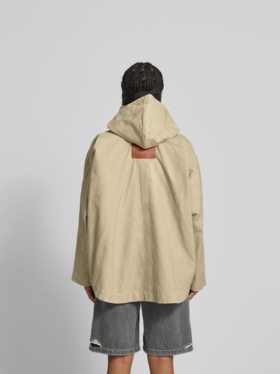 Frauenmodel trägt Jacke aus reiner Baumwolle mit Kapuze von Victoria Beckham in Beige, lockere Passform, Ganzkörperansicht Rückansicht.