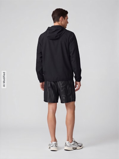 Männermodel trägt Regular Fit Trainingsjacke mit Kapuze von Nike in Schwarz, glatte Struktur, Herren Trainingsjacke, Ganzkörperansicht Rückansicht, KI-modifiziertes Bild.