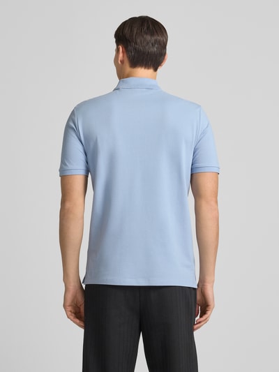 Männermodel trägt Regular Fit Poloshirt aus reiner Baumwolle Modell 'DONOS222' von HUGO in Hellblau, unifarben, Piqué-Struktur, Ganzkörperansicht Rückansicht.