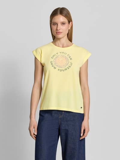 Frauenmodel trägt T-Shirt mit Statement-Print von G.I.G.A. DX in Gelb, Material-Mix mit Baumwoll-Anteil, Regular-Fit, Rundhalsausschnitt, Rückenlänge bei Größe 36: 61 cm, schlichte Struktur, Ganzkörperansicht von vorne.