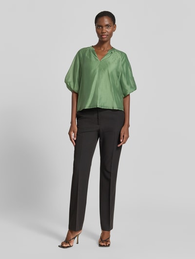 Frauenmodel trägt Loose Fit Blusenshirt aus Lyocell-Mix von s.Oliver BLACK LABEL, Optik: Unifarben, V-Ausschnitt, Raffungen, Puffärmel, Raglanärmel, Material: Lyocell-Mix, Glanzstruktur, Ganzkörperansicht von vorne.
