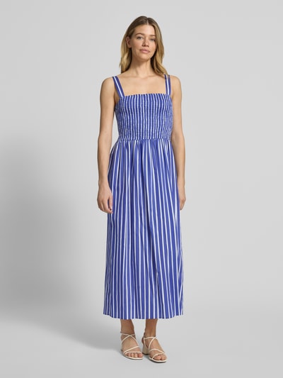 Frauenmodel trägt Midikleid im Allover-Look mit Smok-Details von Marc Cain, reine Baumwolle, gerade Form, vertikale blaue und weiße Streifen, Ganzkörperansicht von vorne.