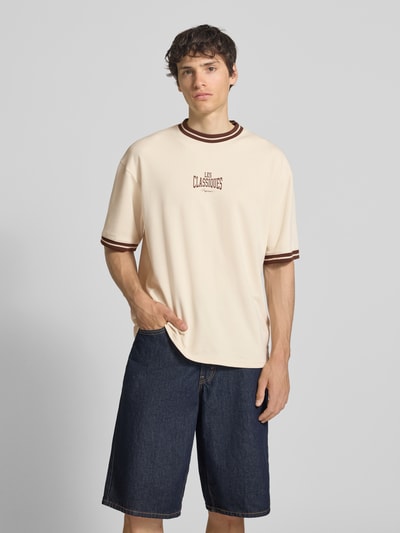 Männermodel trägt Boxy Fit T-Shirt aus reiner Baumwolle Modell 'LES' von Only & Sons, Optik: Unifarben, Label-Print, Nahaufnahme Oberkörper.