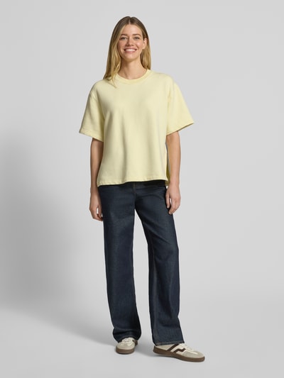 Frauenmodel trägt Sweatshirt mit 1/2-Arm und Rundhalsausschnitt von Rich & Royal in Pastellgelb, lockerer Schnitt, Bio-Baumwoll-Mix, Ganzkörperansicht von vorne.