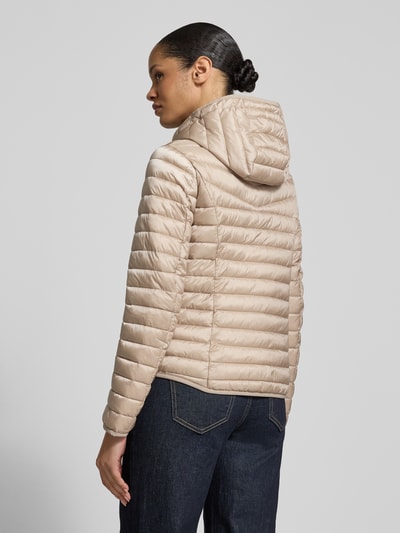 Modelka nosi Steppjacke mit Zweiwege-Reißverschluss od Fuchs Schmitt, kolor beżowy, krój regular fit, kaptur, stójka, kieszenie na zamek, długość tyłu w rozmiarze 36: 61 cm, szerokość ramion w rozmiarze 36: 42 cm, szerokość w rozmiarze 36: 49 cm, długość rękawa w rozmiarze 36: 66 cm, tekstura pikowana, widok całej sylwetki z tyłu