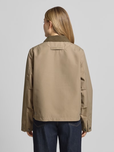 Frauenmodel trägt Jacke mit Zweiwege-Reißverschluss Modell 'ROBINSON' von Samsøe Samsøe, beige, glatte Textur, Regular-Fit, Umlegekragen, Brusttasche, Rückenlänge 61 cm, Schulterbreite 43 cm, Brustweite 41 cm, Ärmellänge 64 cm, Ganzkörperansicht Rückansicht.