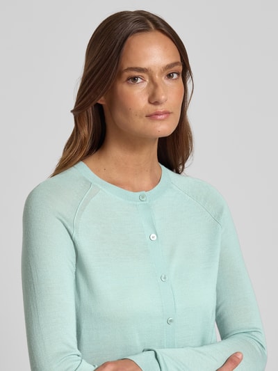 Modelka kobieca nosi Regular Fit Strickjacke aus reiner Schurwolle Modell 'FONAMI' von BOSS, efekt: jednolity kolor, krój regular fit, listwa guzikowa jednorzędowa, okrągły dekolt, długie raglanowe rękawy, prążkowane wykończenia, drobny splot, materiał: czysta żywa wełna, zbliżenie na górną część ciała z przodu.
