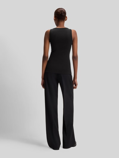 Frauenmodel trägt Slim Fit Tank Top aus Baumwoll-Mix Modell 'DATAMIA' von HUGO in Schwarz mit breiten Trägern, Feinrippstruktur, Ganzkörperansicht Rückansicht.