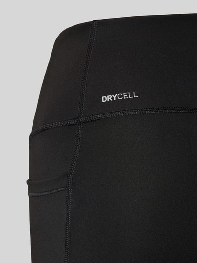 Nahaufnahme Oberschenkel, Frauenmodel trägt Flared Leggings mit Logo von PUMA aus schwarzem Material-Mix mit Stretch-Anteil, glatte Textur.