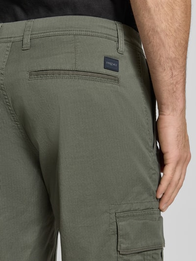 Mężczyznamodel nosi Regular Fit Cargoshorts aus Baumwoll-Mix von Tom Tailor, efekt: jednolity kolor, z fakturą, mieszanka bawełny, naszywka z logo, kieszenie z wypustkami, kieszeń cargo, zapięcie na guzik i zamek błyskawiczny, detal pikowany; detailaufnahme tyłu.