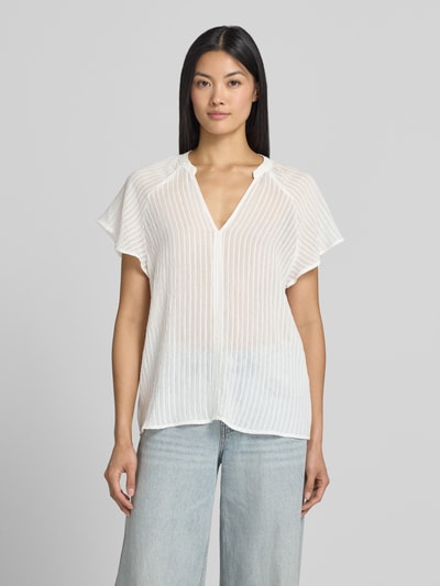 Vrouwenmodel draagt Blusenshirt aus Viskose-Mix mit Raglanärmeln van zero, wit met structuurpatroon, serafinohals, loose fit, ruglengte maat 36: 61 cm, mouwlengte maat 36: 24 cm, ganzkörperaanzicht van voren.