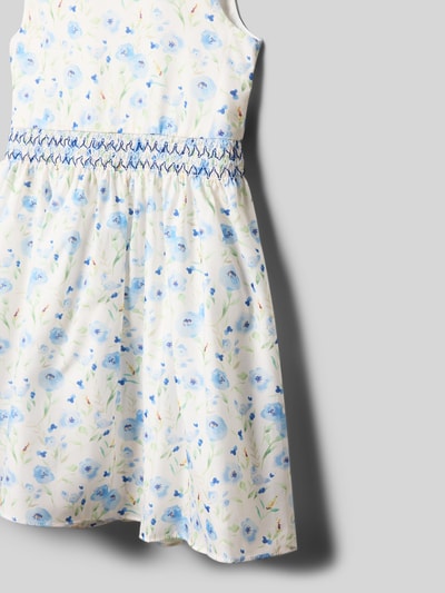 Meisje draagt Regular Fit jurk met bloemen all-over print van DANAMADE, wit met blauwe bloemen, mouwloos design, detailopname.