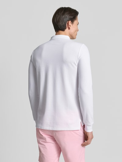 Männermodel trägt Regular Fit Poloshirt aus reiner Baumwolle von Polo Ralph Lauren, weiß, Langarm, Piqué-Textur, Ganzkörperansicht Rückansicht.