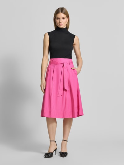 Vrouwenmodel draagt Regular Fit midirok in plooien-look van Christian Berg Woman van puur katoen, met stoffen band en ritssluiting, geheel vooraanzicht.